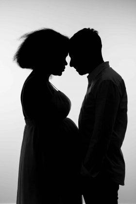 Photo de silhouette artistique d'un couple attendant un enfant face à face, en contre-jour noir et blanc, réalisée par un photographe professionnel à Wattignies