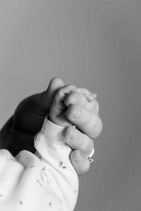 Bébé souriant assis dans un décor automnal avec des citrouilles et des feuilles mortes, séance photo à thème à Wattignies