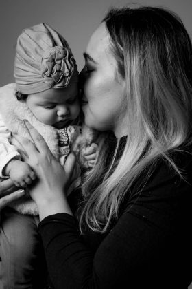 Photo noir et blanc d'une maman tenant son bébé portant un turban, moment de tendresse capturé par un photographe famille à Lille