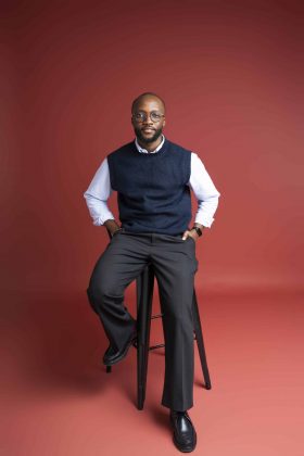 Portrait vertical d’un homme sur fond rouge